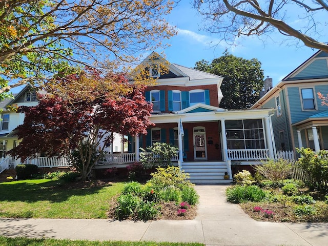 view of front of property featuring a porch, a front yard, and fence