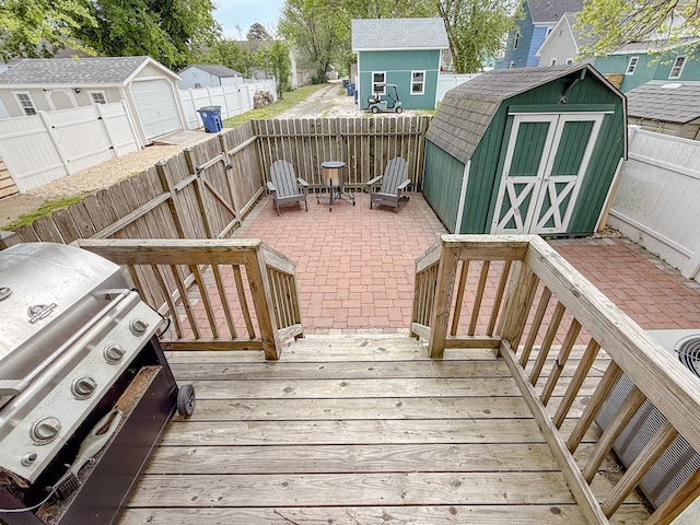 510 Plum St, Cape Charles, VA 23310 - wooden deck with a grill, a storage unit, a fenced backyard, and an outdoor structure