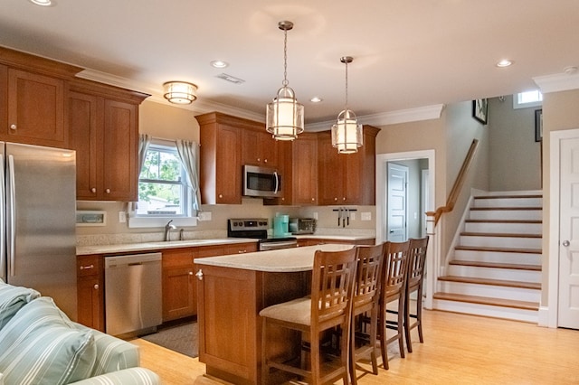 510 Plum St, Cape Charles, VA 23310 - kitchen featuring a kitchen breakfast bar, brown cabinets, a sink, appliances with stainless steel finishes, and light countertops