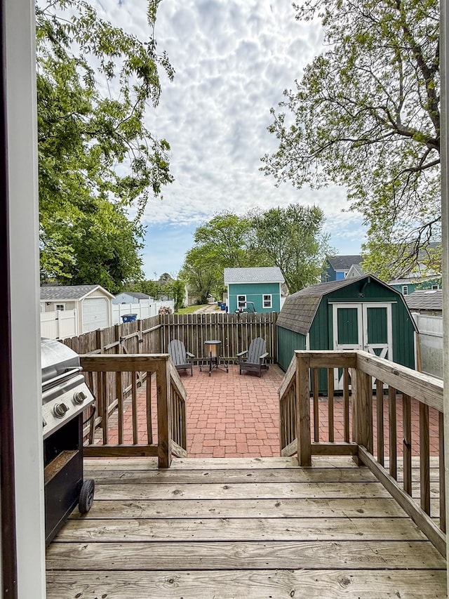 510 Plum St, Cape Charles, VA 23310 - wooden terrace featuring an outdoor structure, a patio, a storage unit, and a fenced backyard