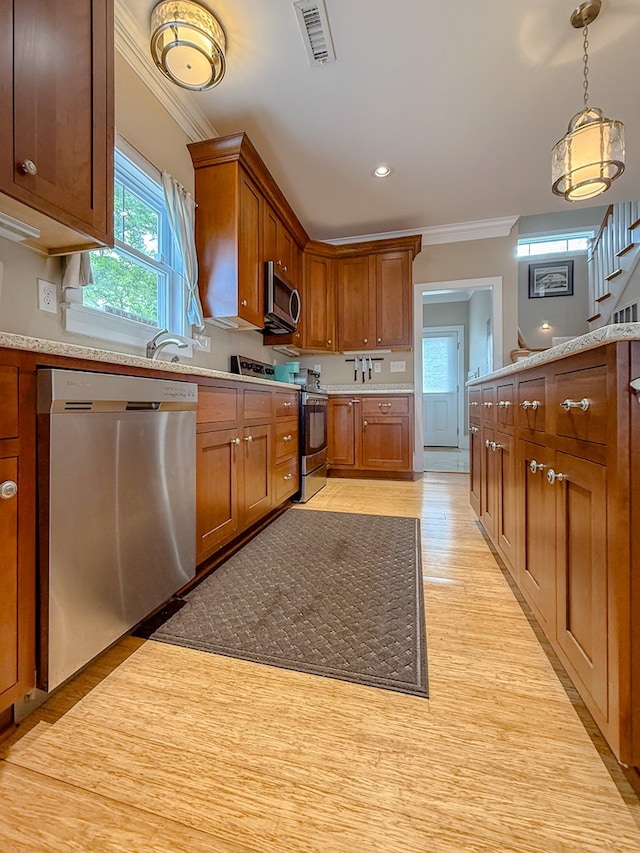 510 Plum St, Cape Charles, VA 23310 - kitchen with stainless steel appliances, brown cabinetry, visible vents, light countertops, and ornamental molding