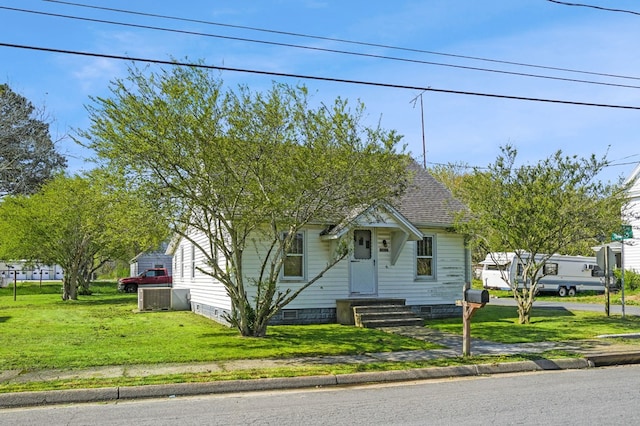 view of front of house with a shingled roof and a front lawn