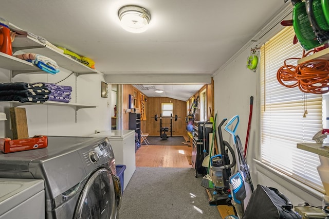 laundry room featuring independent washer and dryer, wood finished floors, wooden walls, and laundry area