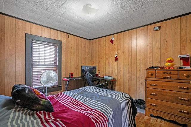 bedroom featuring wood finished floors and wood walls