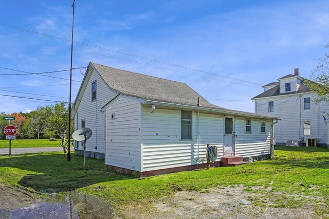 back of house featuring a yard and central AC