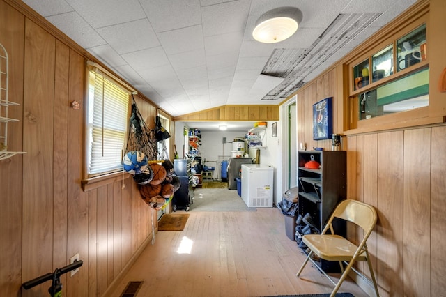 corridor featuring visible vents, hardwood / wood-style flooring, and wood walls