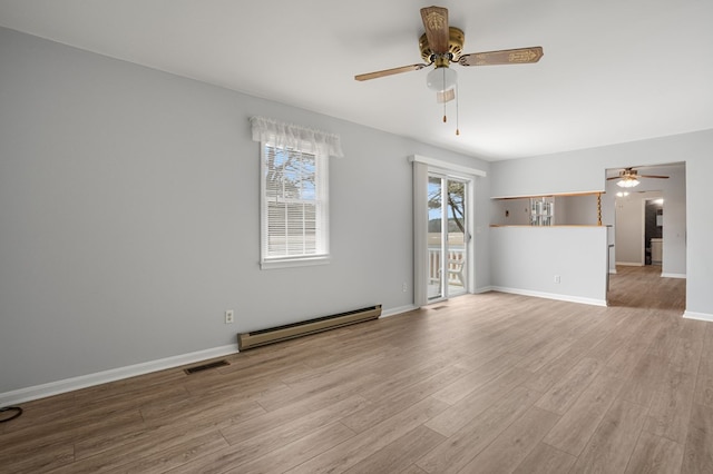 empty room featuring ceiling fan, a baseboard radiator, and light wood-type flooring