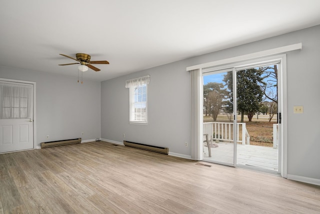 empty room with a baseboard heating unit, ceiling fan, and light wood-type flooring