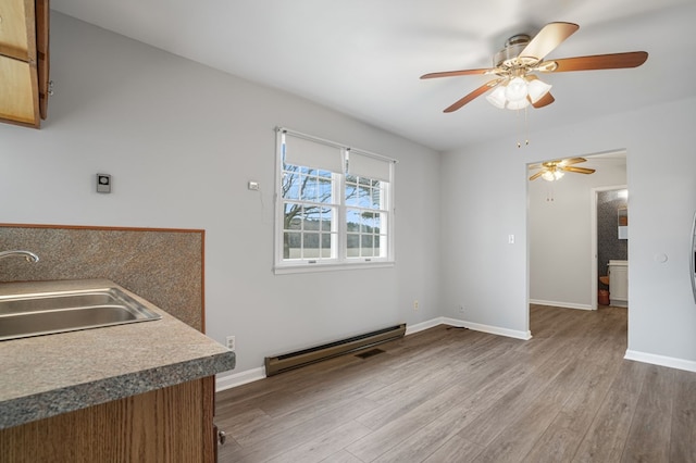 dining room featuring sink, light hardwood / wood-style floors, and baseboard heating