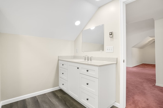 bathroom featuring vanity, lofted ceiling, and wood-type flooring