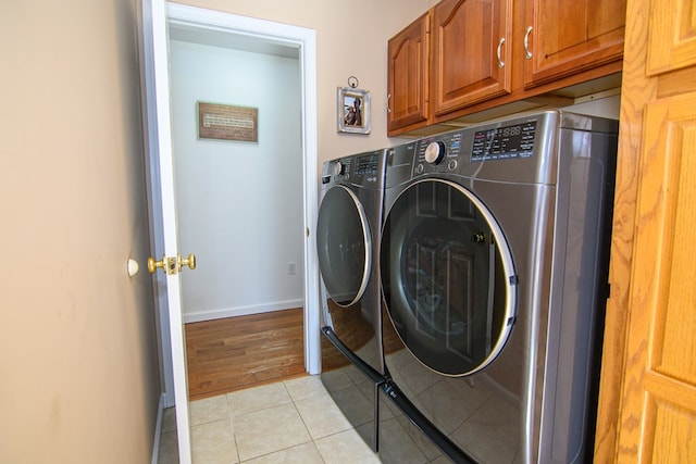 6545 Occohannock Neck Rd, Exmore, VA 23350 - clothes washing area featuring baseboards, cabinet space, washing machine and dryer, and light tile patterned flooring