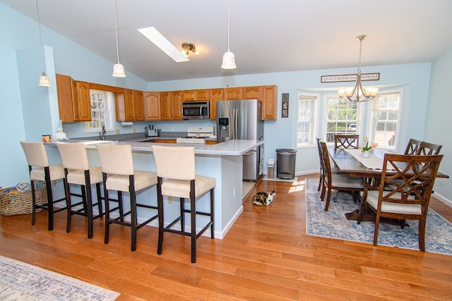 6545 Occohannock Neck Rd, Exmore, VA 23350 - kitchen featuring a kitchen bar, a peninsula, light wood-type flooring, and stainless steel appliances
