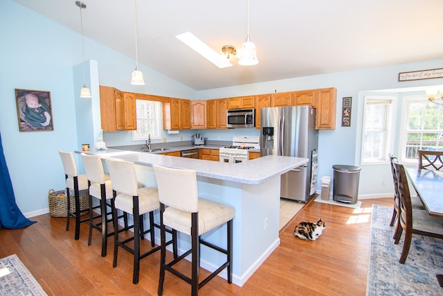 6545 Occohannock Neck Rd, Exmore, VA 23350 - kitchen with a kitchen bar, a sink, light wood-style floors, appliances with stainless steel finishes, and a peninsula