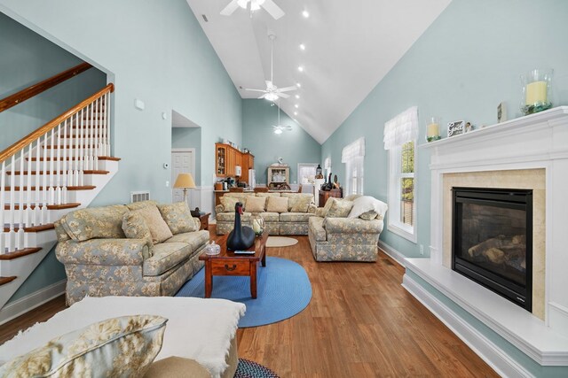 living room featuring hardwood / wood-style flooring, high vaulted ceiling, and ceiling fan