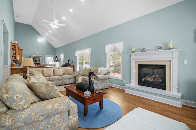 living room with hardwood / wood-style floors, high vaulted ceiling, and ceiling fan