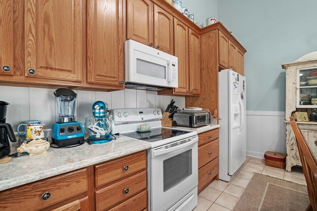 kitchen featuring light tile patterned floors and white appliances