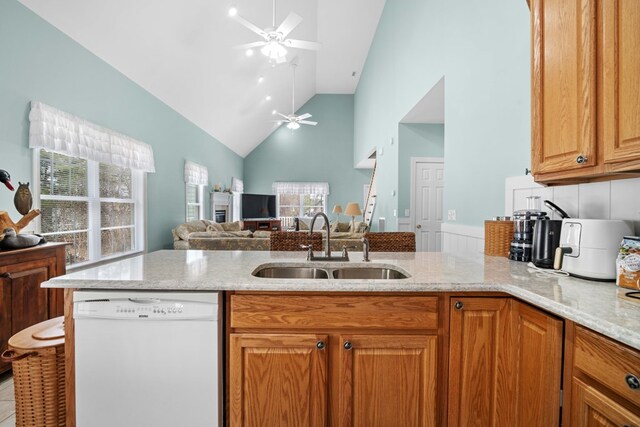 kitchen featuring ceiling fan, sink, white dishwasher, and light stone countertops