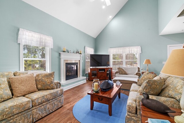 living room featuring hardwood / wood-style floors, ceiling fan, and high vaulted ceiling