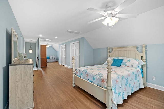 bedroom with ceiling fan, lofted ceiling, and light hardwood / wood-style flooring