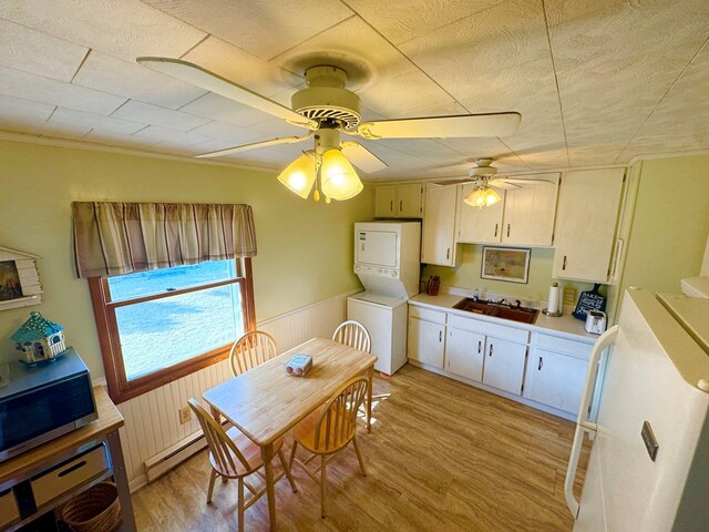 3434 Willow St, Chincoteague, VA 23336 - kitchen featuring stacked washer / drying machine, freestanding refrigerator, wainscoting, light wood-style flooring, and light countertops
