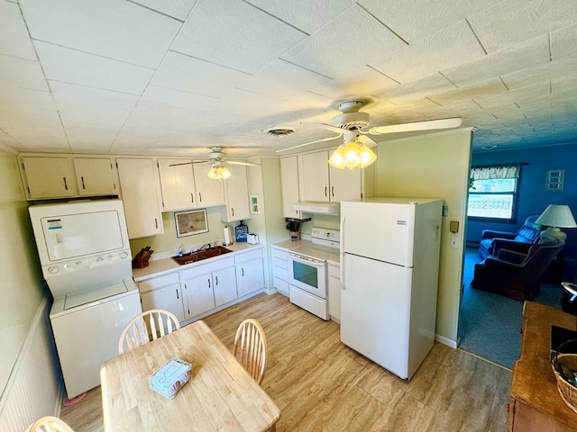 3434 Willow St, Chincoteague, VA 23336 - kitchen featuring white appliances, a ceiling fan, stacked washing machine and dryer, under cabinet range hood, and light countertops