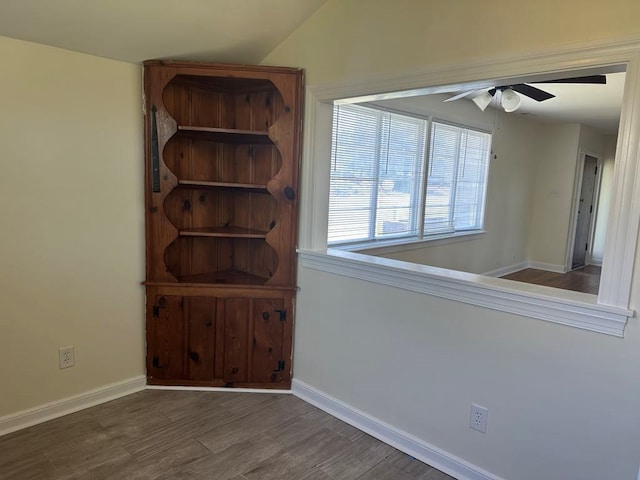 spare room with baseboards, ceiling fan, and wood finished floors