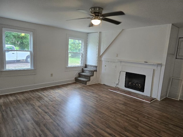 30423 Bobtown Rd, Pungoteague, VA 23421 - unfurnished living room with a fireplace with raised hearth, wood finished floors, ceiling fan, and stairway