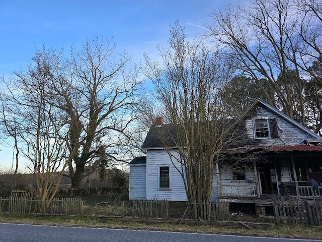 view of side of property featuring covered porch