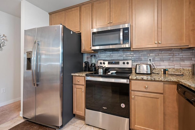 kitchen featuring light stone countertops, appliances with stainless steel finishes, tasteful backsplash, and light tile patterned floors