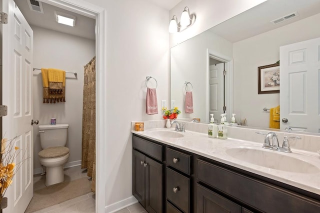 bathroom featuring tile patterned floors, vanity, and toilet