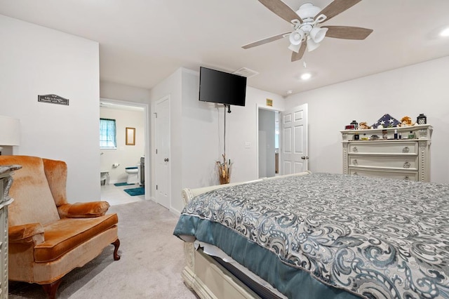 carpeted bedroom with ensuite bathroom and ceiling fan