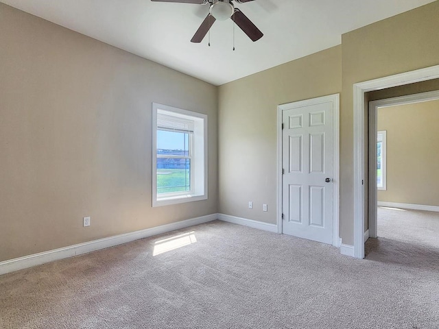 spare room featuring light carpet and ceiling fan