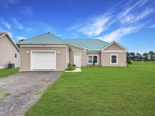 view of front of property featuring cooling unit, a garage, and a front lawn