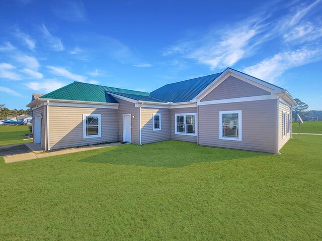 view of front of property featuring a garage, cooling unit, and a front lawn