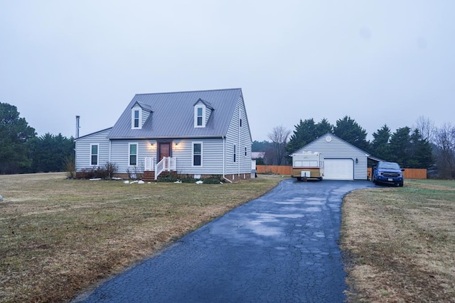 cape cod house with a garage, an outdoor structure, and a front lawn