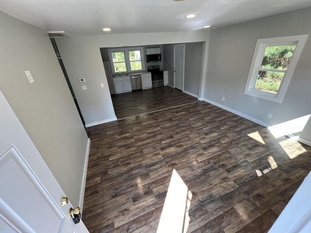 unfurnished living room with dark hardwood / wood-style floors and sink