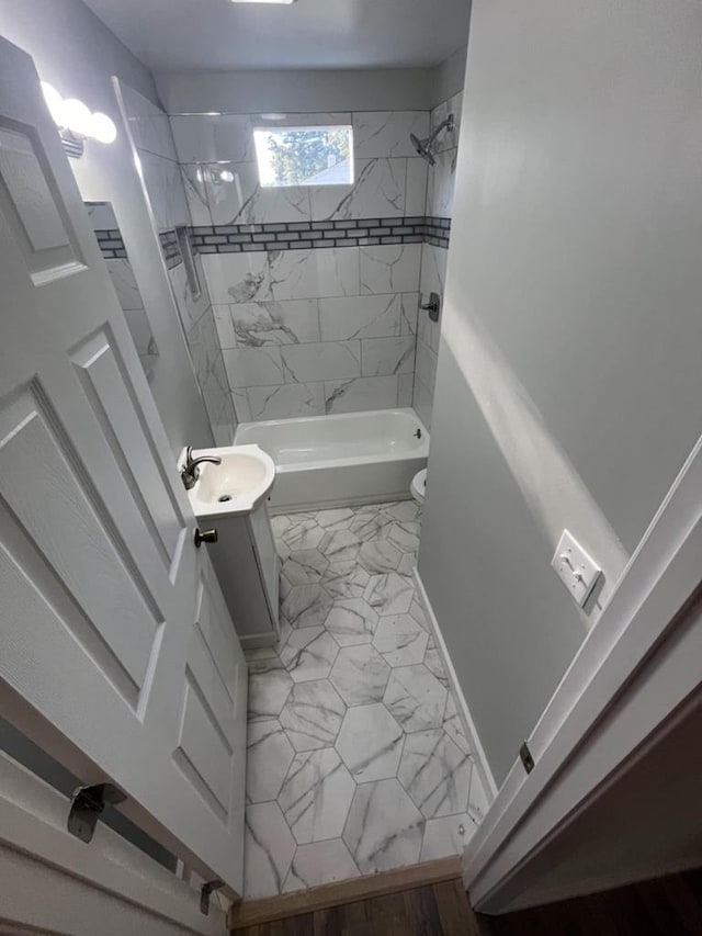 full bathroom featuring tiled shower / bath, vanity, and toilet