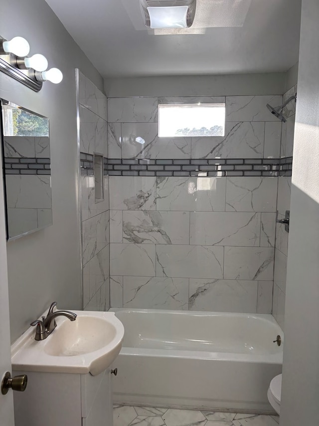 full bathroom featuring tiled shower / bath combo, toilet, and vanity