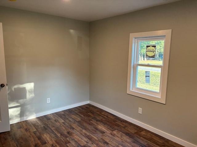 empty room with dark hardwood / wood-style flooring