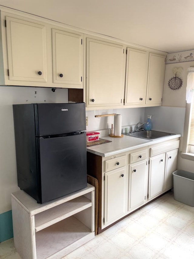 kitchen featuring black fridge and sink