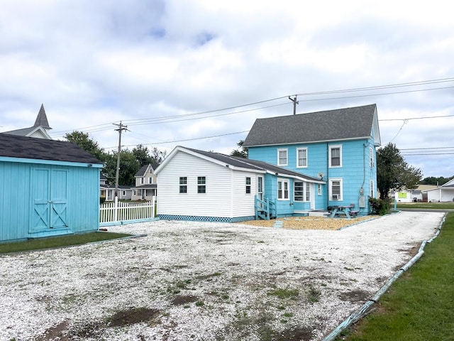 back of property with a storage shed