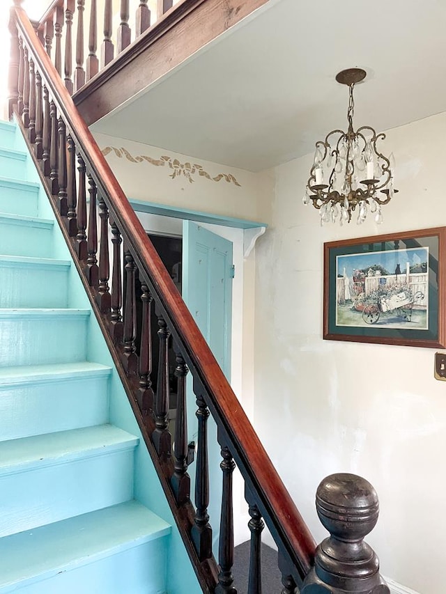 staircase with a chandelier