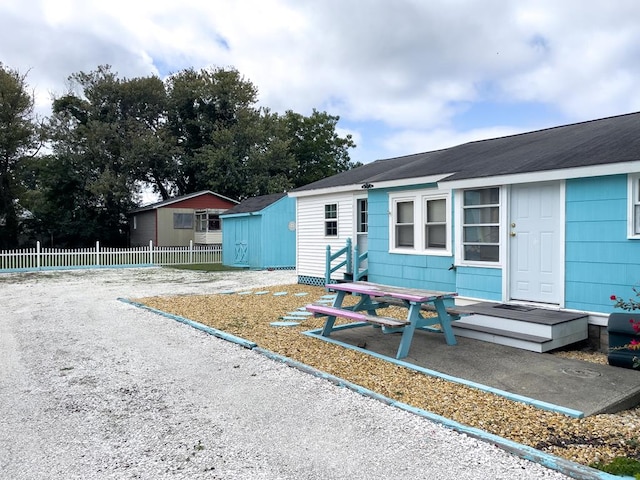 view of front of property with a storage shed and a patio area