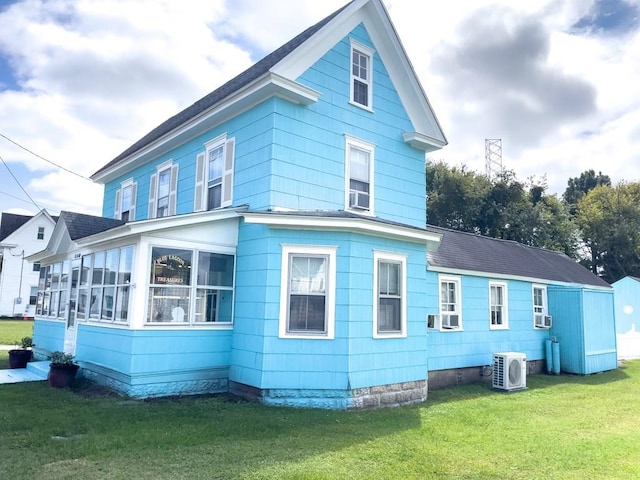 back of house with ac unit, a yard, and cooling unit