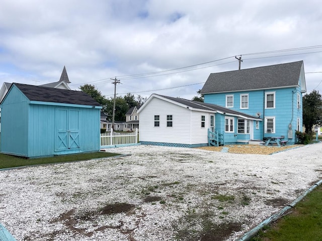 back of property with a storage shed