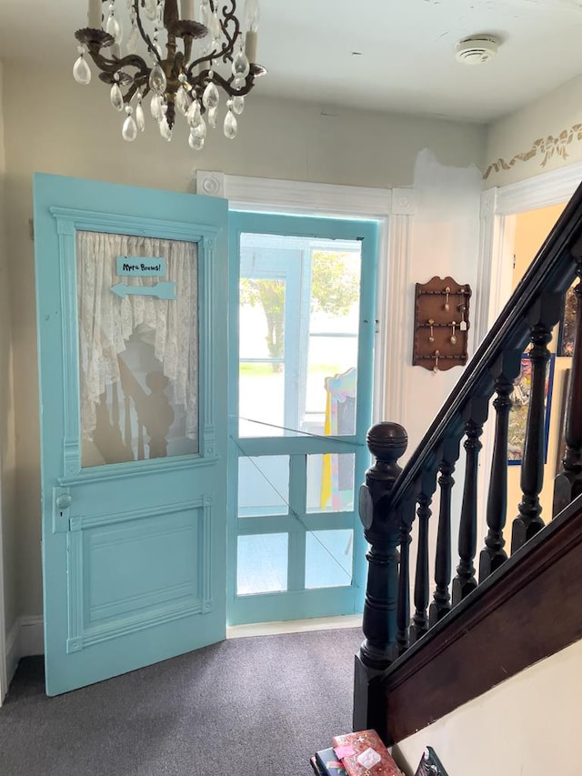 doorway featuring an inviting chandelier and carpet flooring