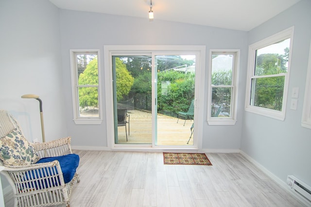 entryway featuring light hardwood / wood-style floors, lofted ceiling, and a baseboard radiator