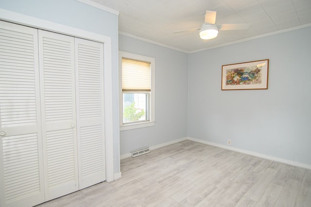 unfurnished bedroom with a closet, light hardwood / wood-style flooring, ceiling fan, and ornamental molding