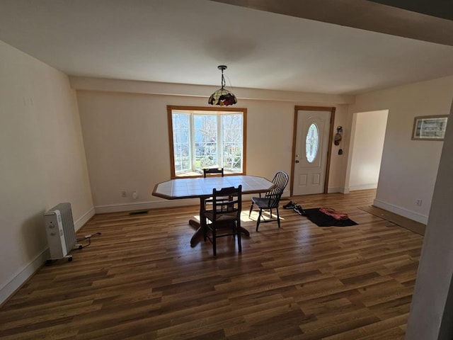 dining space with baseboards, wood finished floors, and visible vents