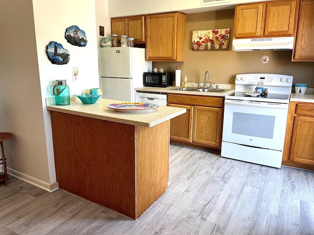 kitchen featuring kitchen peninsula, sink, white appliances, and light hardwood / wood-style flooring